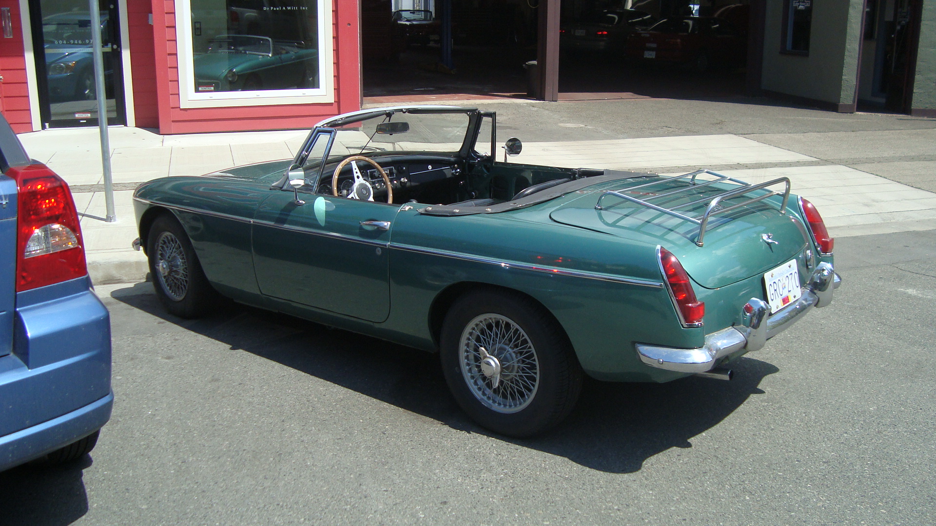 Green 1964 MG MGB roadster parked on Delta Street outside Ladner Motors in Delta BC